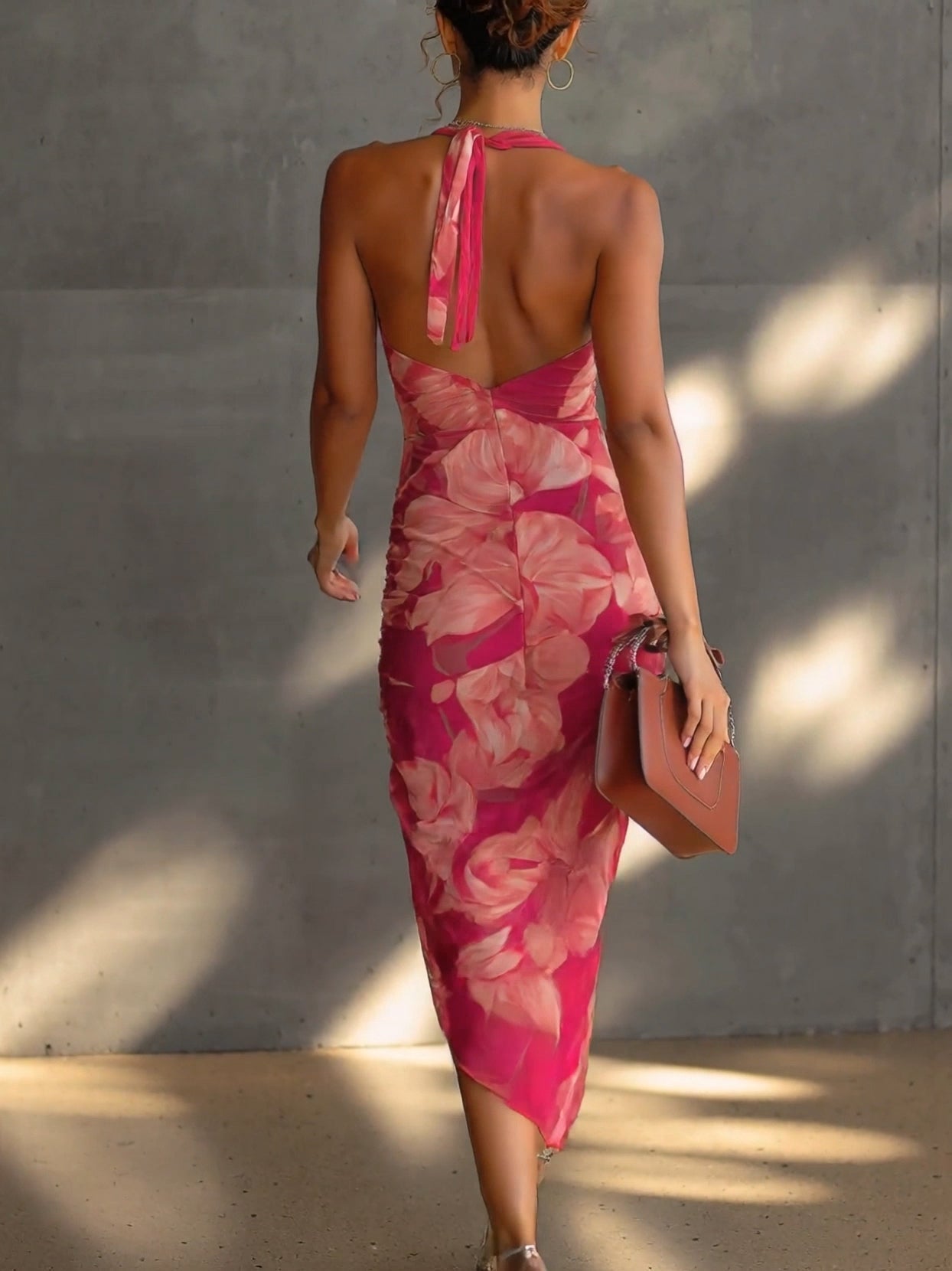 Vestido ajustado de color fucsia con estampado floral, sin mangas, fruncido en los laterales y con abertura